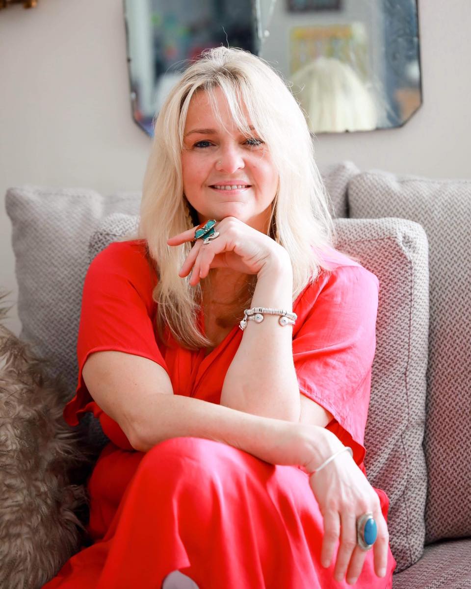 Australian Fertility Summit Founder Liz Walton - an image of a woman with blond hair and blue eyes seated with hand horizontally under chin looking at the camera