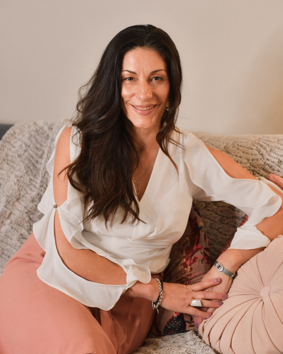 Australian Fertility Summit Founder Liz Walton - an image of a woman with blond hair and blue eyes seated with hand horizontally under chin looking at the camera